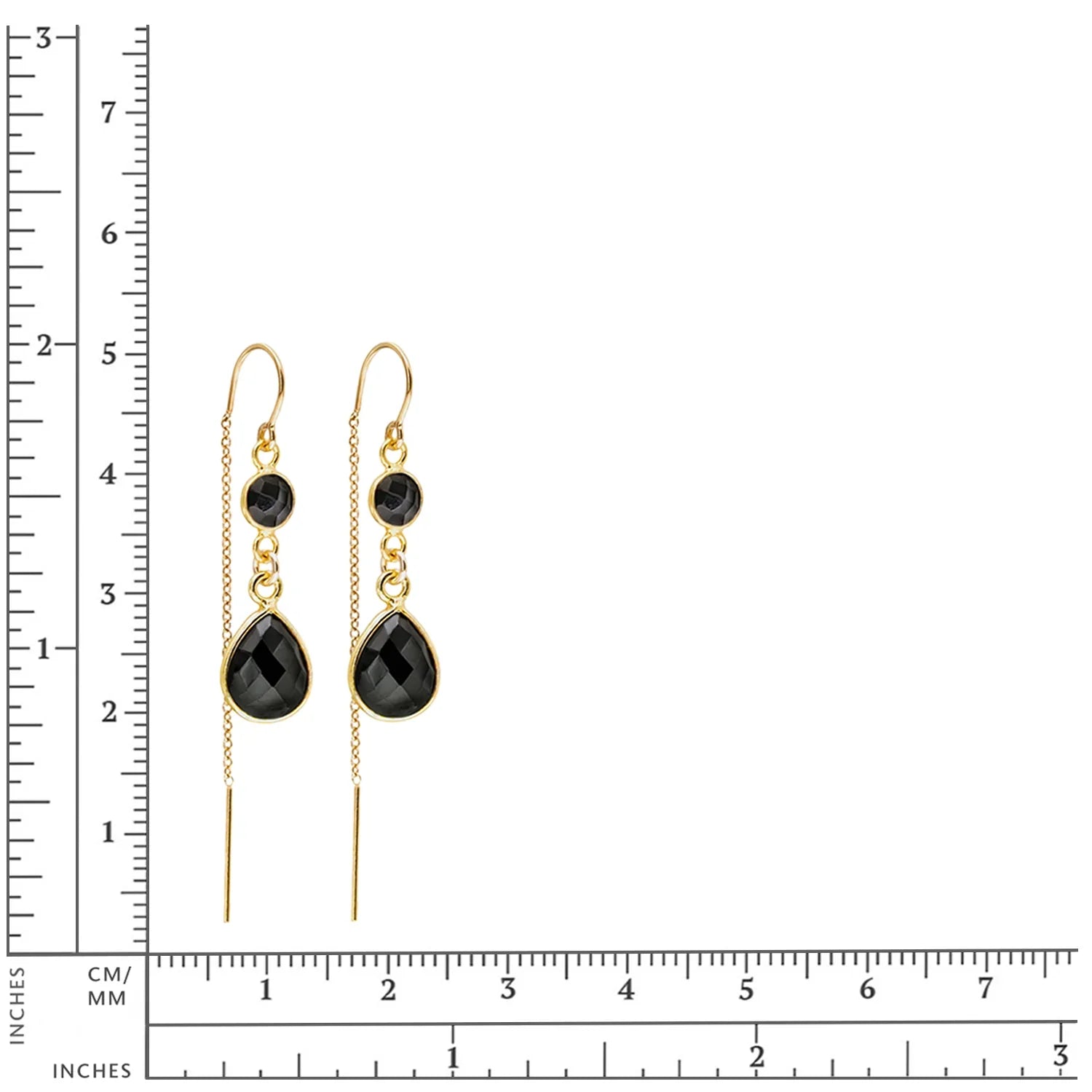 Gold earrings with black teardrop beads next to a measurement scale on a white background
